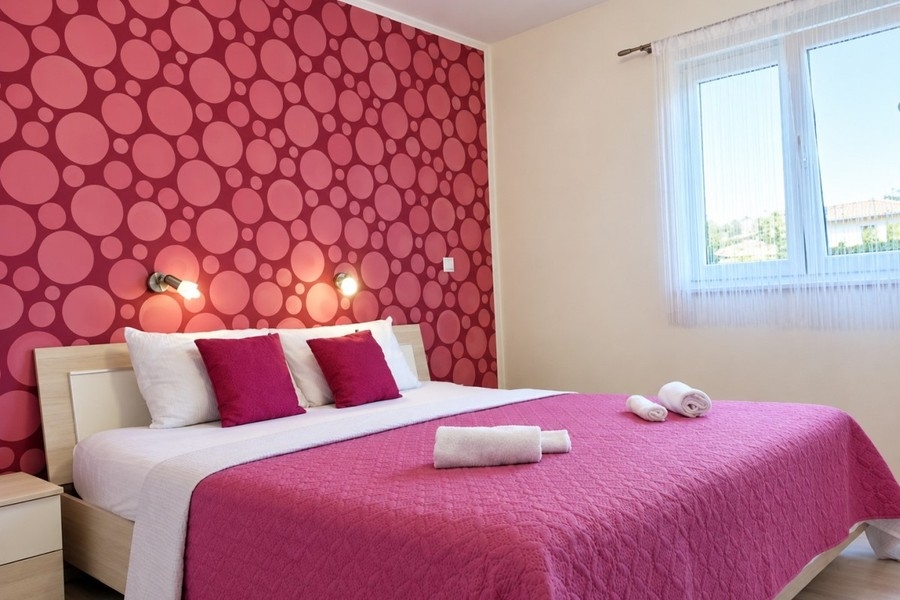 Camera da letto con letto matrimoniale e parete decorata