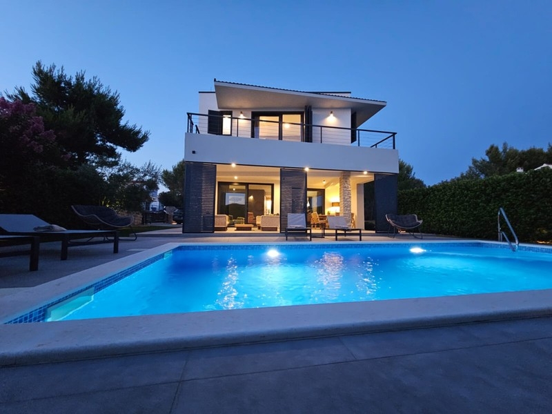 Villa illuminata con piscina la sera
