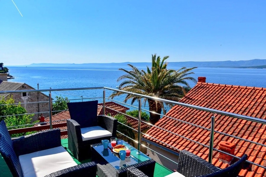 Casa con appartamenti e vista mare sull'isola di Brac, terrazza con palme