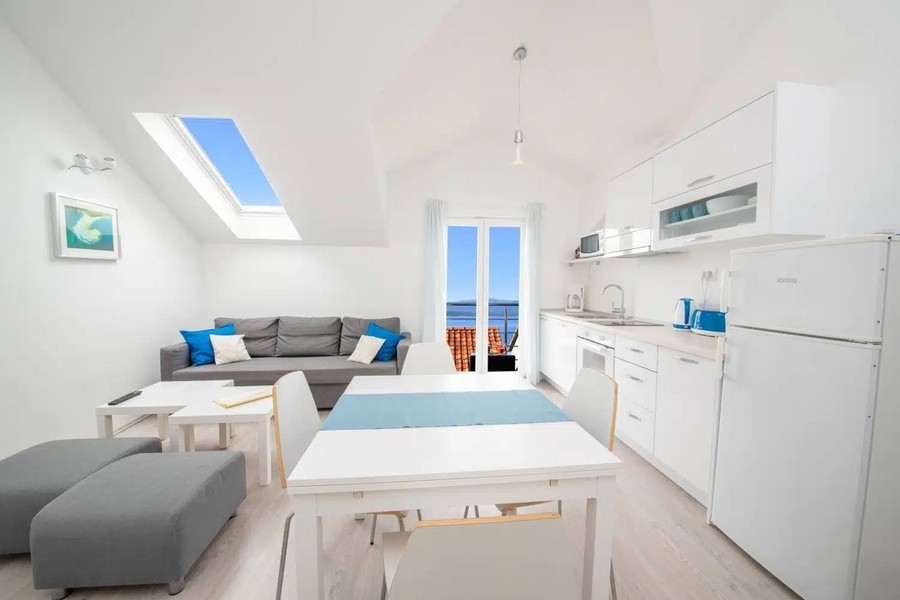 Zona giorno aperta con cucina e vista sul balcone