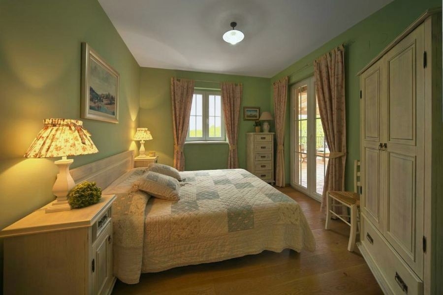 Camera da letto con letto matrimoniale e pareti verdi