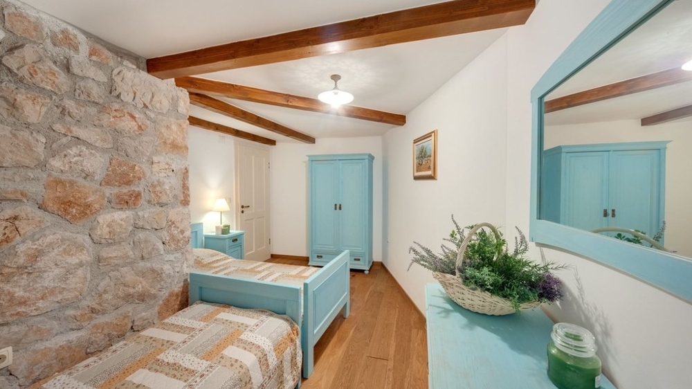Stanza con parete in pietra naturale e letto singolo