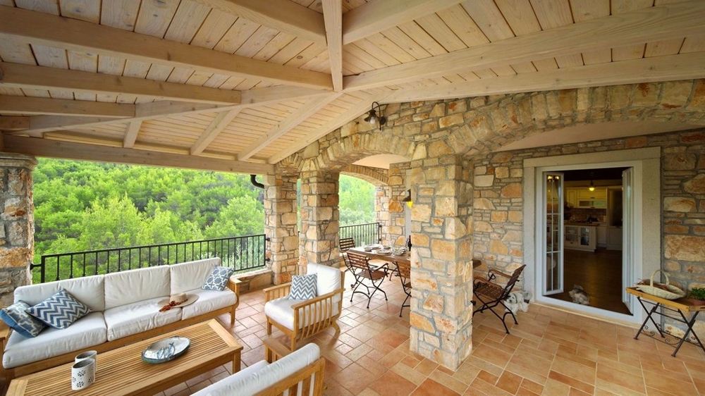 Terrazza lounge con soffitto in legno e vista sul verde
