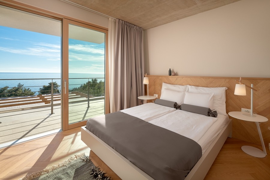 Camera da letto con grande vetrata e vista mare