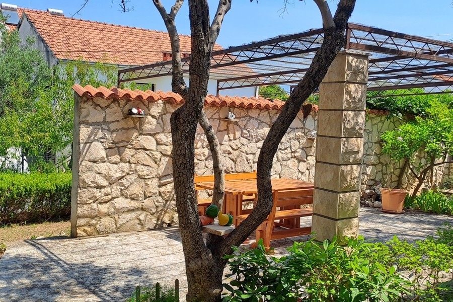 Cortile interno con muro in pietra e mobili da giardino