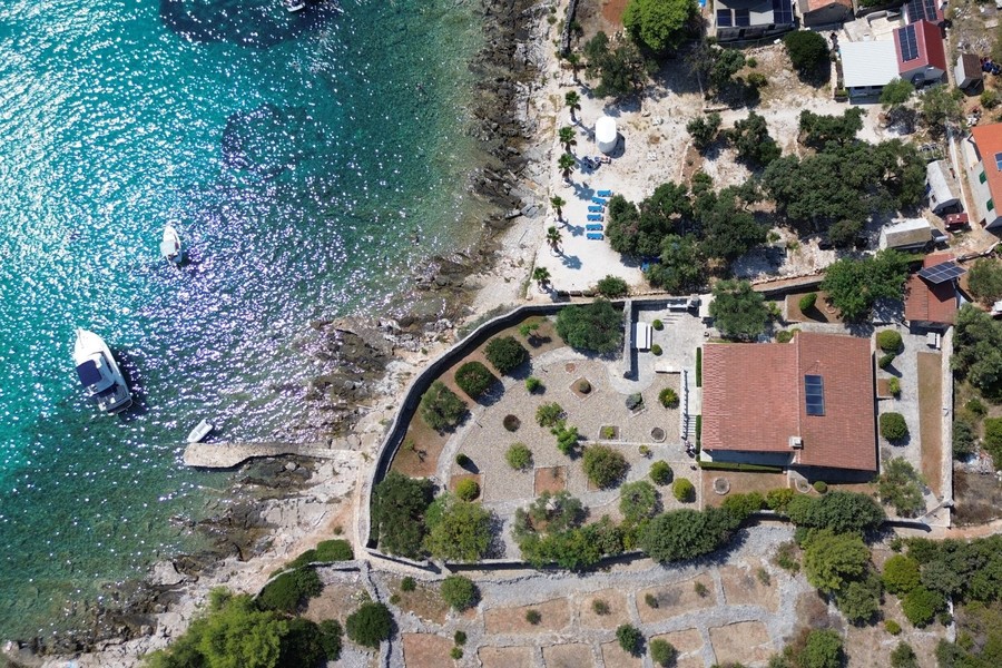 Veduta aerea della baia con villa in pietra sull'acqua