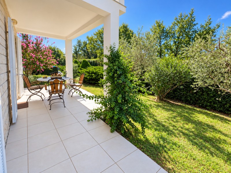 Terrazza coperta con zona salotto sul giardino