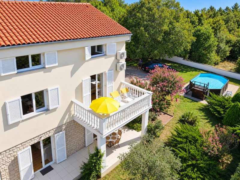 Balcone con sdraio sopra il giardino con piscina