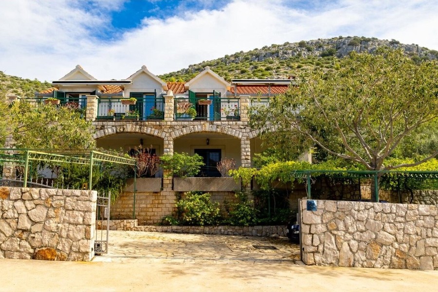 Vista della casa con muro in pietra naturale e arcate al piano terra