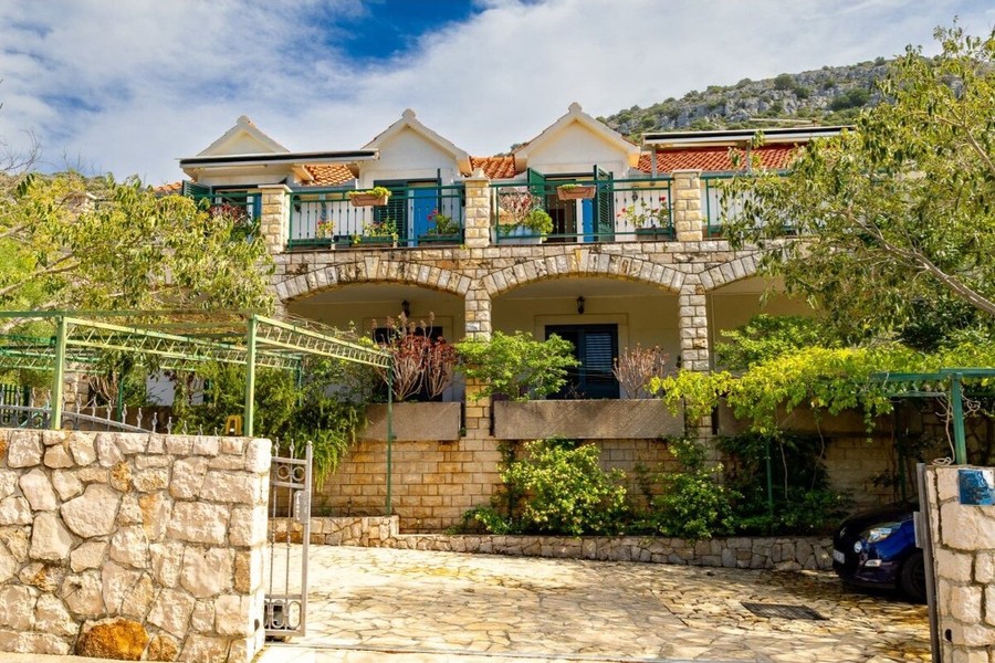 Casa con muro in pietra e accesso carrabile nel verde
