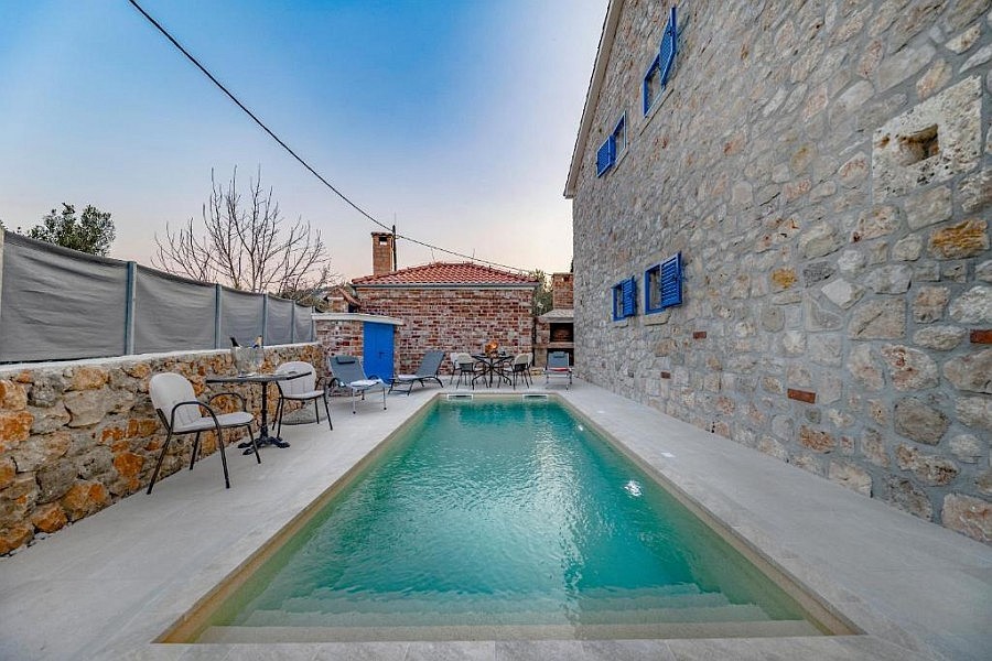 Piscina davanti alla facciata in pietra naturale