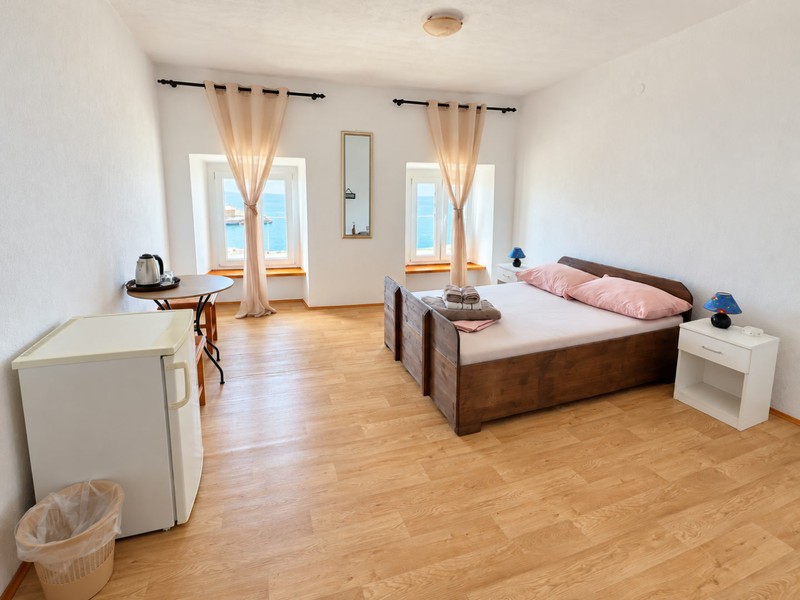 Camera da letto luminosa con pavimento in legno
