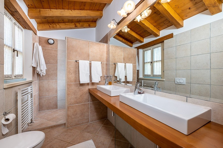 Bagno con due lavabi e mensola in legno