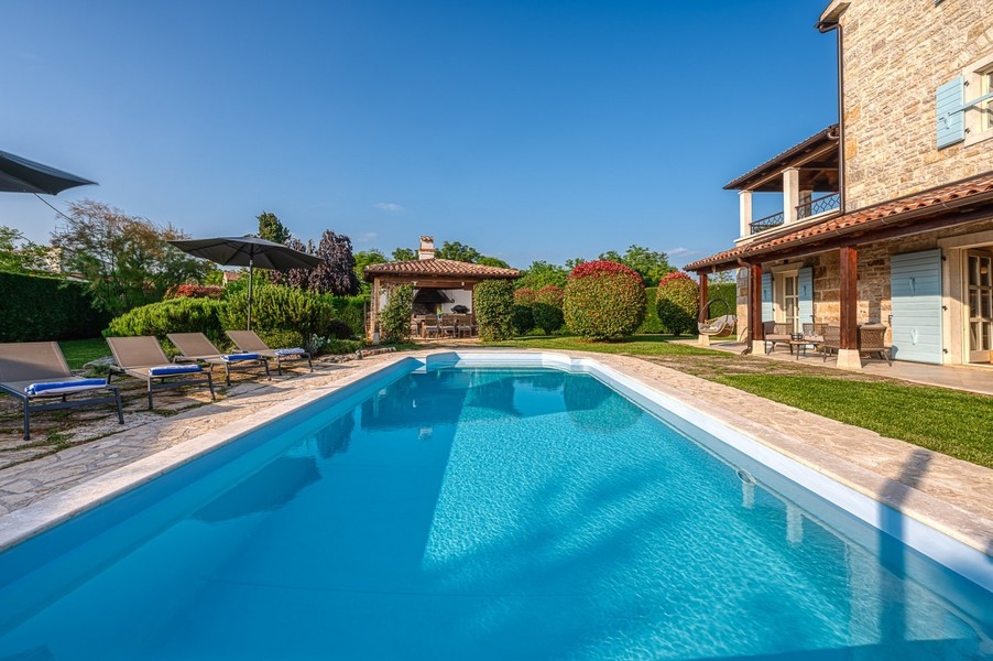 Piscina con vista sul gazebo da giardino e sulla casa