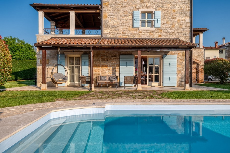 Facciata della casa con terrazza dietro la piscina