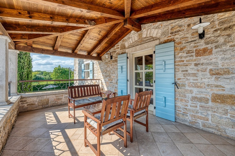 Terrazza con mobili in legno e vista sul verde