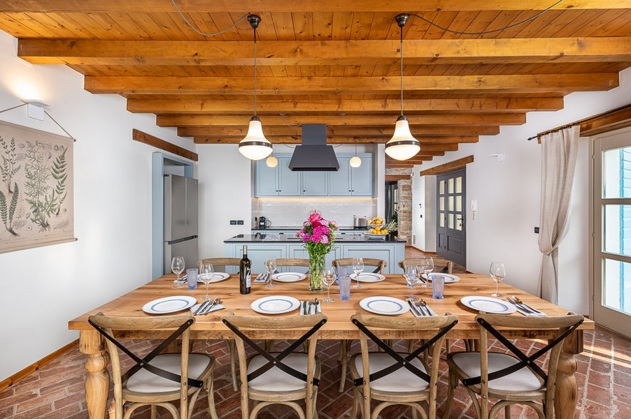 Tavola apparecchiata in cucina con soffitto a travi di legno