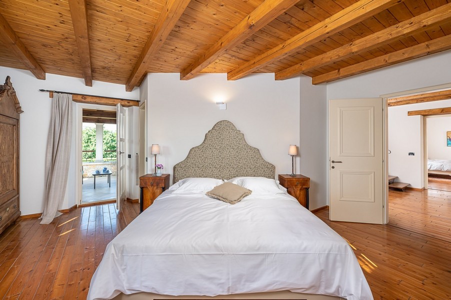 Camera da letto con testiera imbottita e pavimento in legno