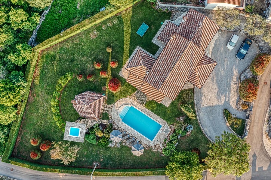 Vista aerea di casa, piscina e giardino con siepe
