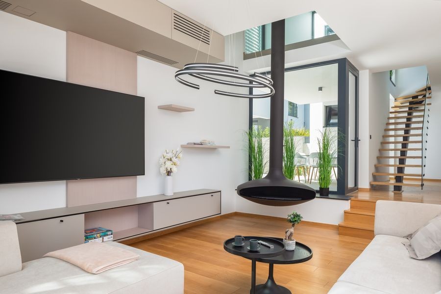 Zona living con camino sospeso e scala