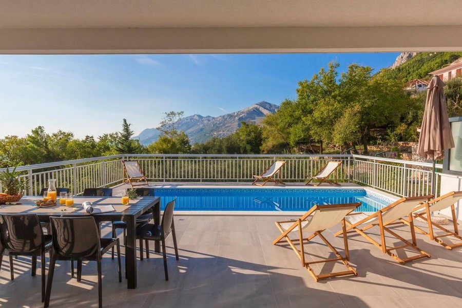 Piscina con lettini e vista sulle montagne