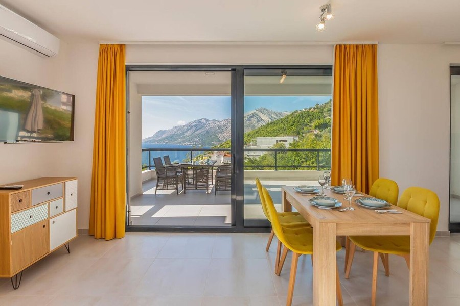 Zona pranzo con sedie gialle e vista mare