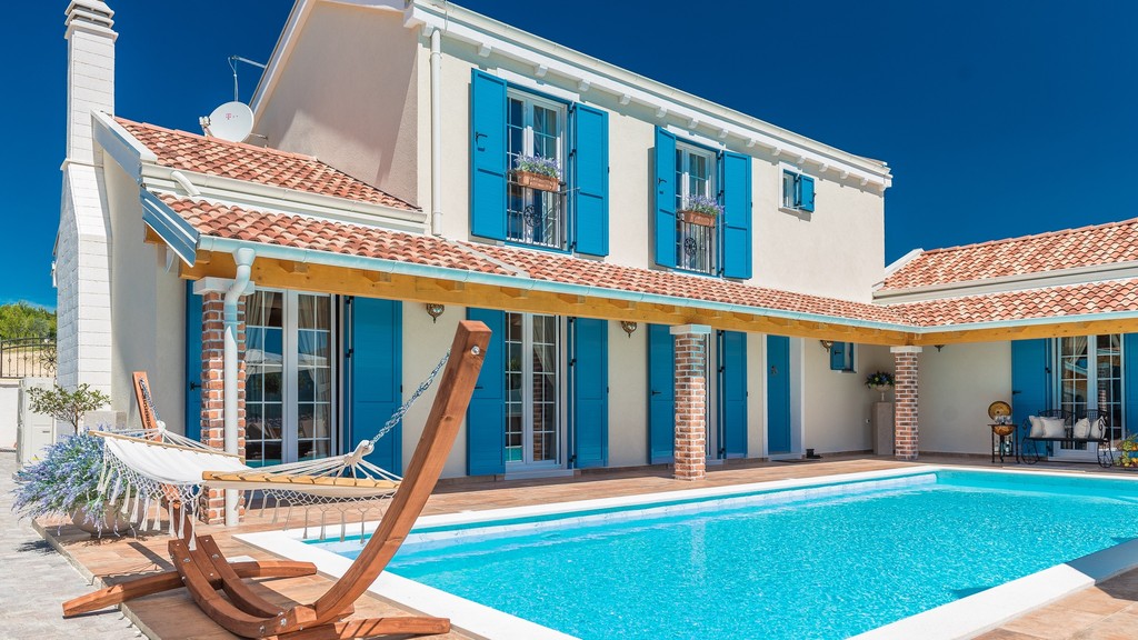 Villa con persiane blu e piscina