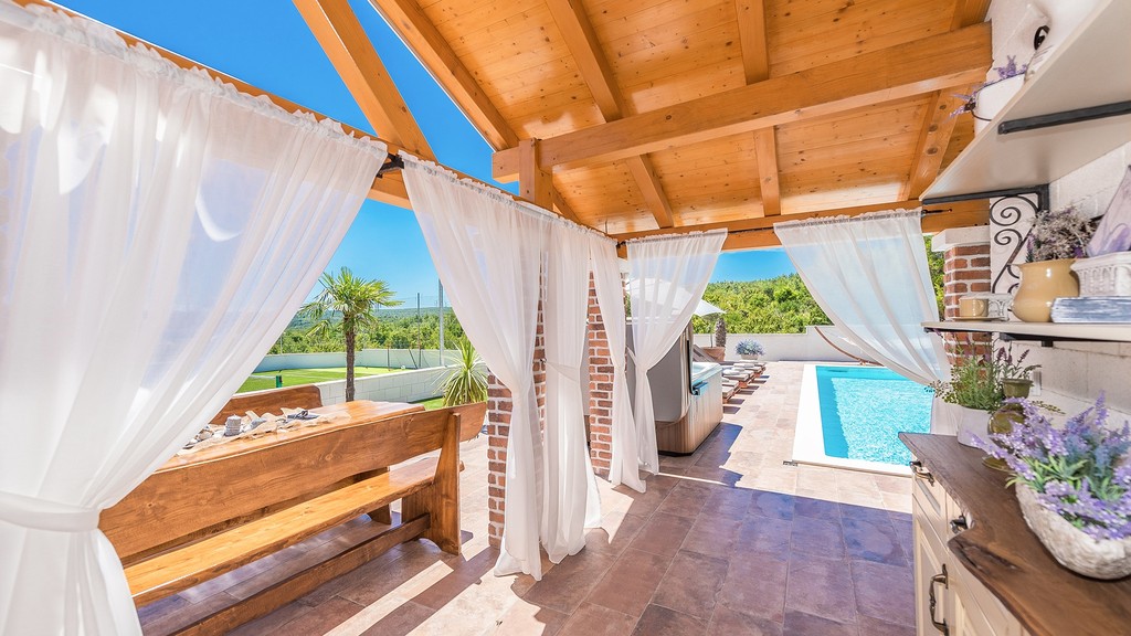 Terrazza con tetto in legno e vista sulla piscina