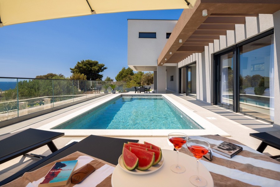 Piscina con lettini e vista sul mare