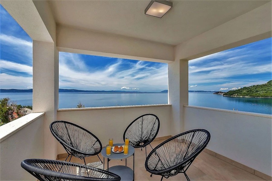 Terrazza coperta con poltrone e vista mare