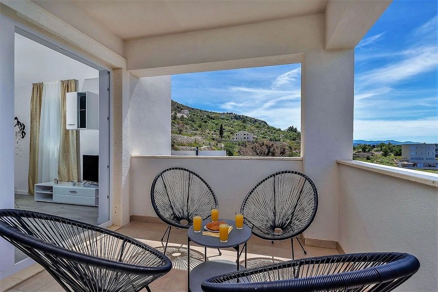 Terrazza con poltrone di vimini e vista sulla costa