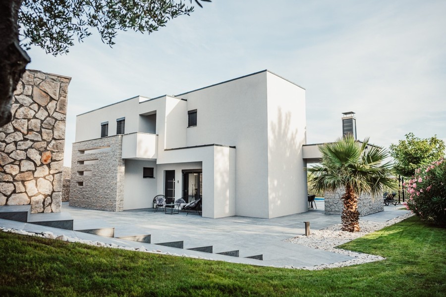 Villa moderna con prato e facciata in pietra