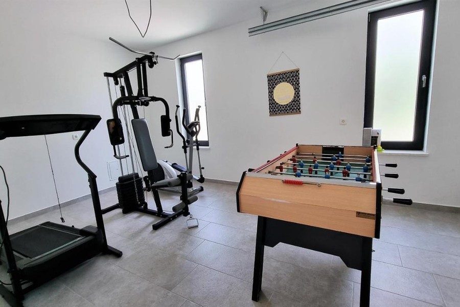 Locale con attrezzi fitness e calciobalilla