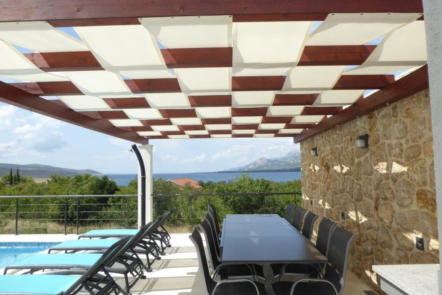 Terrazza coperta con tavolo da pranzo e vista mare