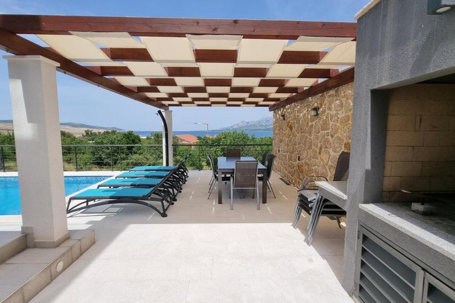 Terrazza con griglia e vista sulla piscina