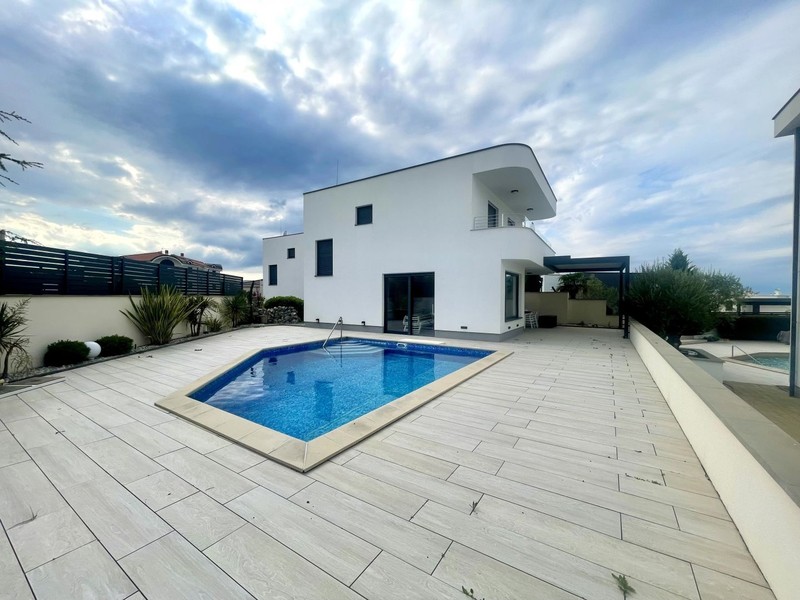 Piscina con terrazza davanti alla casa bianca