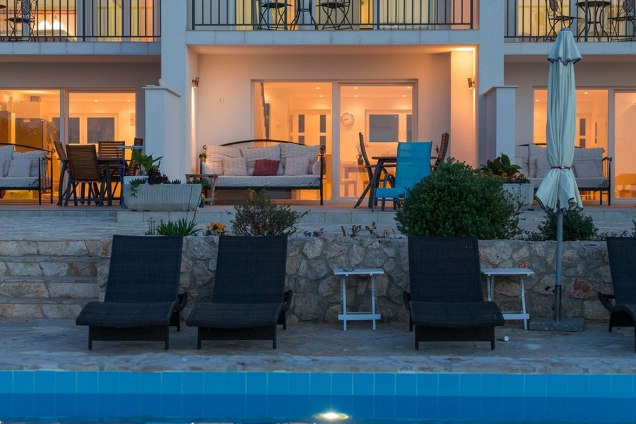 Terrazze delle unità abitative con lettini accanto alla piscina