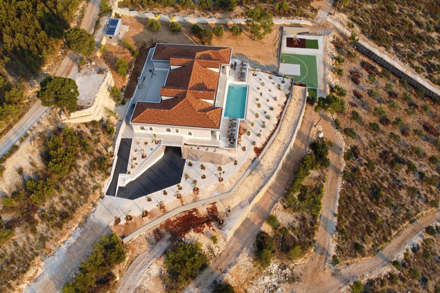 Veduta aerea della villa con piscina e campo sportivo