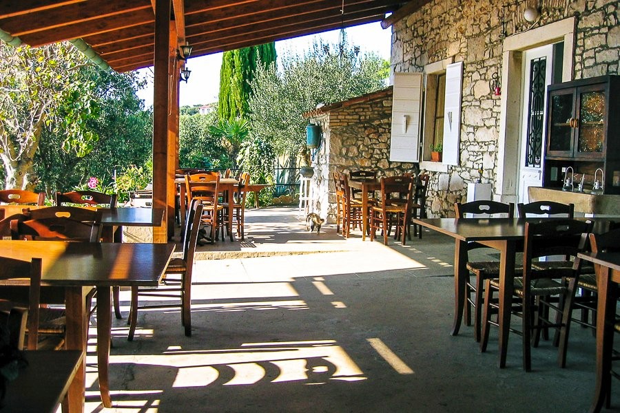 Terrazza coperta con tavoli accanto alla casa in pietra