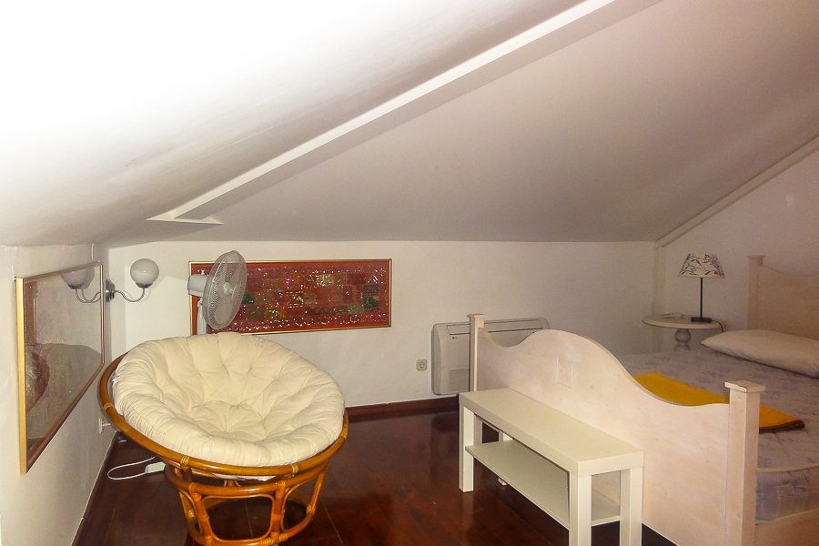Camera mansardata con letto e poltrona