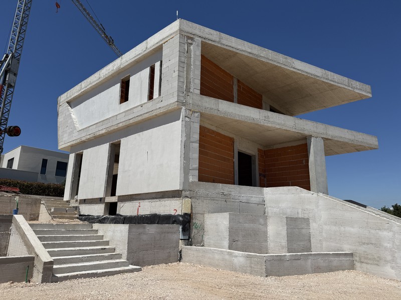 Struttura grezza della villa con scala esterna, stato giugno 2026