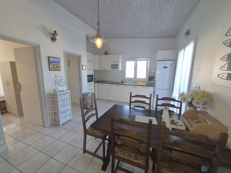 Zona pranzo con tavolo in legno davanti alla cucina