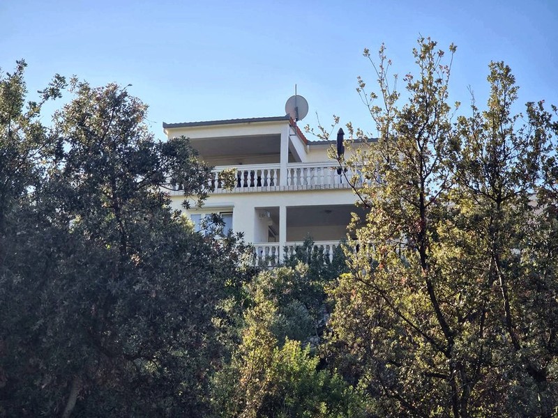 Facciata della casa con balcone tra gli ulivi