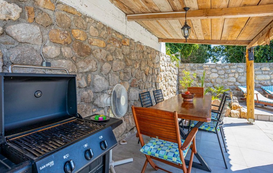 Terrazza coperta con griglia e tavolo da pranzo