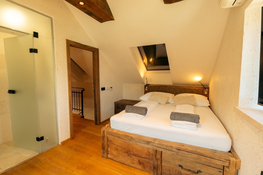 Camera da letto con letto matrimoniale e travi di legno