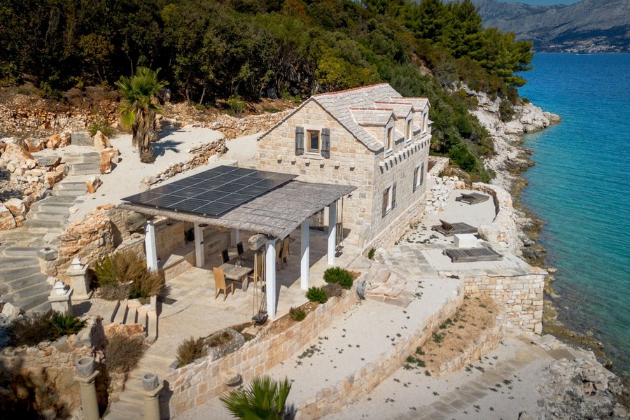 Vista aerea della casa in pietra con terrazza sulla riva