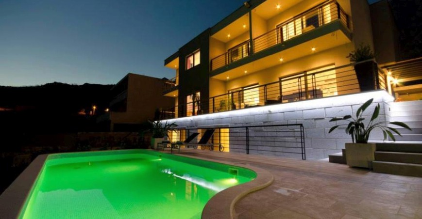 Casa illuminata con piscina dai riflessi verdi alla sera
