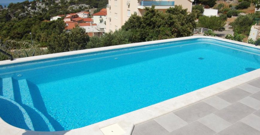 Grande piscina con vista sui tetti fino al pendio