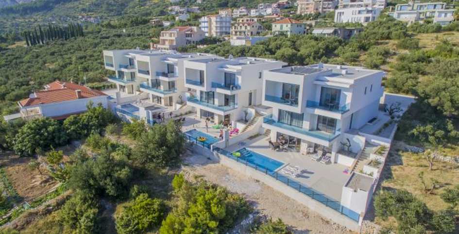 Veduta aerea della fila di case con piscine sul pendio