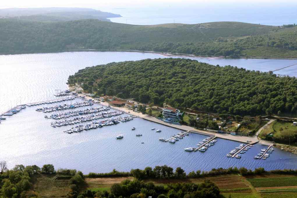 Veduta aerea della marina con pontili e penisola boscosa